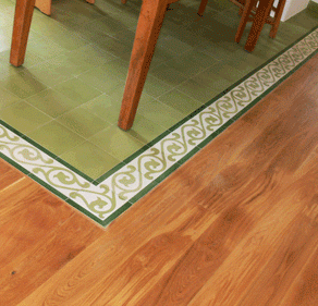 Holzboden und grüne Fliesen mit dekorativem Randmuster.