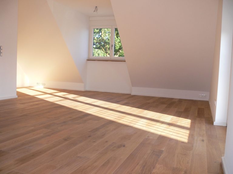 Heller Raum mit Holzfußboden und Dachfenster, das Licht hereinlässt.