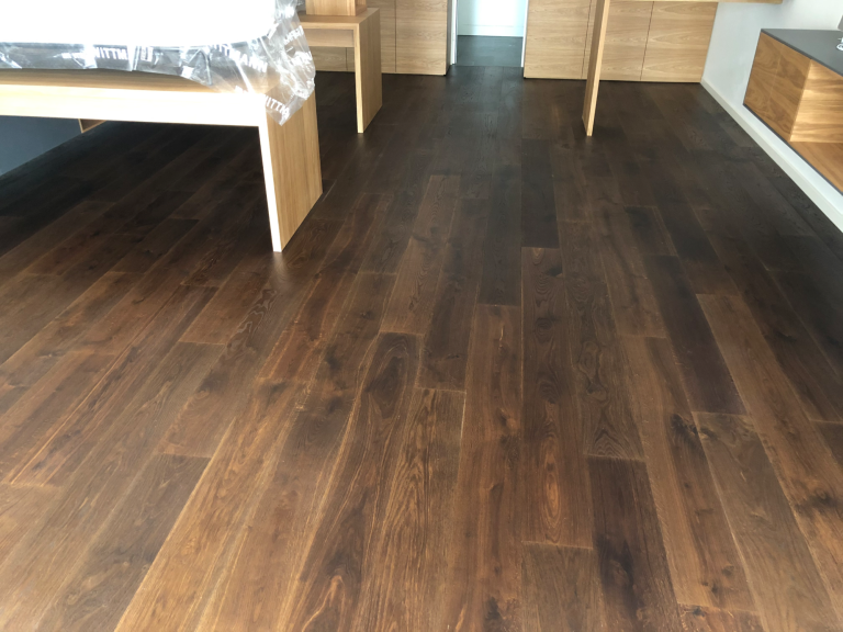 Dunkler Holzfußboden in einem Raum mit Möbeln aus Holz.